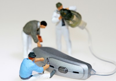 Plastic man repairing hearing aid service image